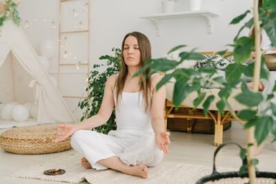 Na imagem, mulher fazendo meditação para ter uma vida equilibrada.